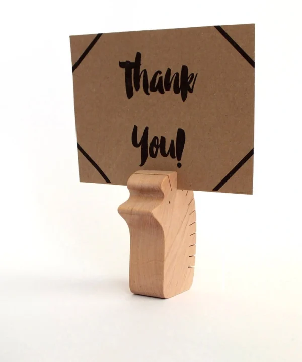 L dydžio medinis ežiukas, laikantis kortelę