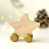 Medinis riedantis žaislas „Žvaigždė“ šventiniame fone