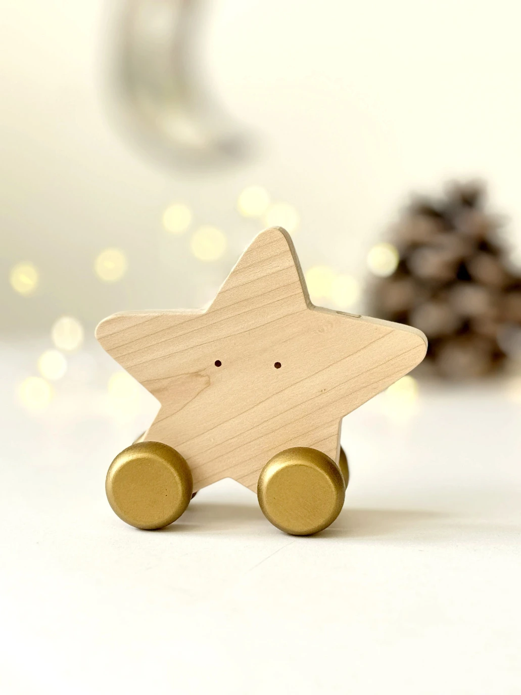 Medinis riedantis žaislas „Žvaigždė“ šventiniame fone