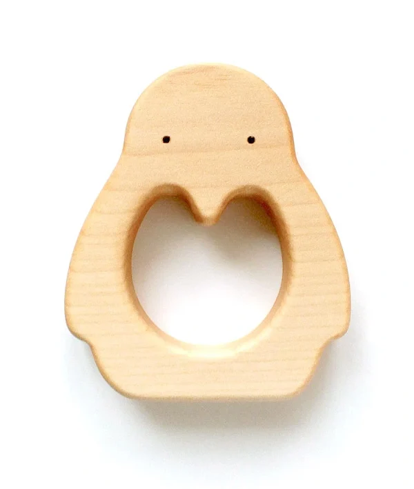 Minimalistinio dizaino, glotnaus paviršiaus medinis kramtukas kūdikiams, vaizduojantis pingviną su apskrita skyle viduryje patogiam suėmimui.