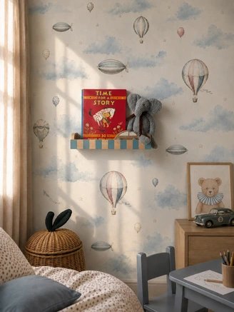 Mėlyna Montessori sieninė knygų lentyna vaikams jaukiame vaikų kambaryje su oro balionų tapetu, knygelėmis ir žaislais.